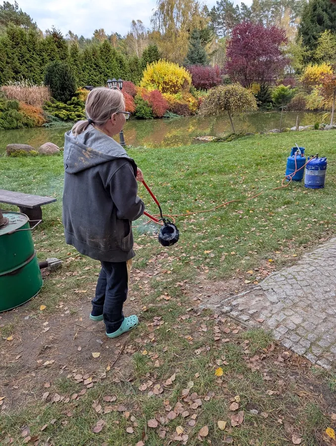 Wyjmowanie gorącego naczynia podczas wypału alternatywnego.