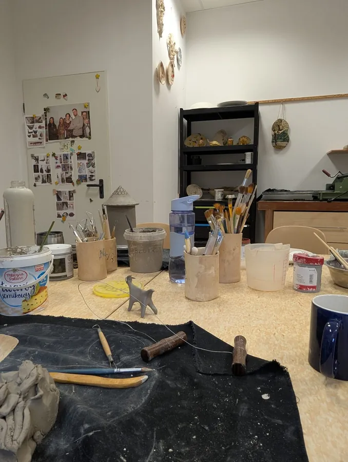 Stół roboczy, glina i narzędzia w pracowni ceramicznej WTZ Lubiatowo.