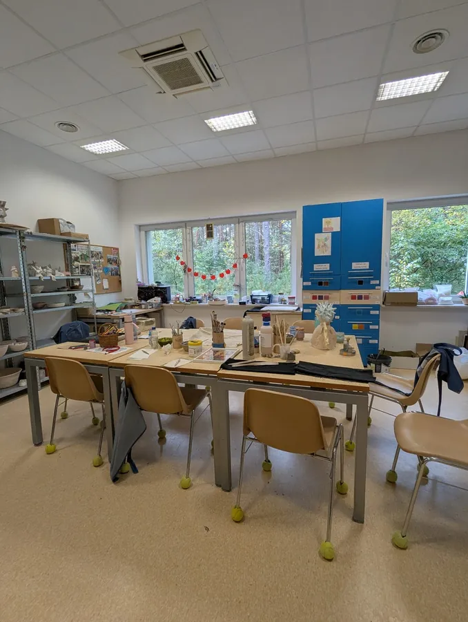 Wnętrze pracowni ceramicznej WTZ Lubiatowo ze stołami przygotowanymi do pracy.