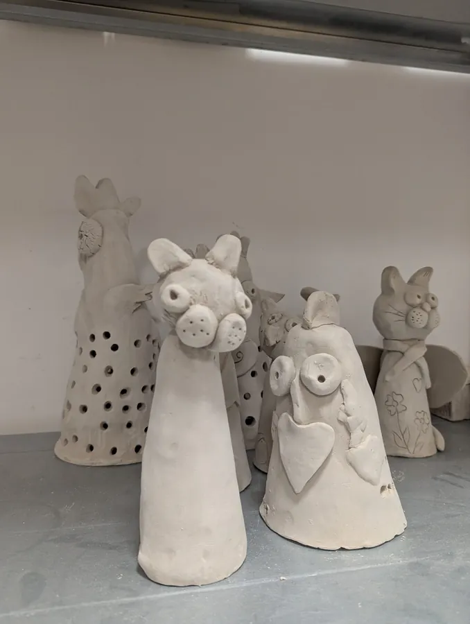 Różne gliniane postaci wykonane w pracowni ceramicznej WTZ.